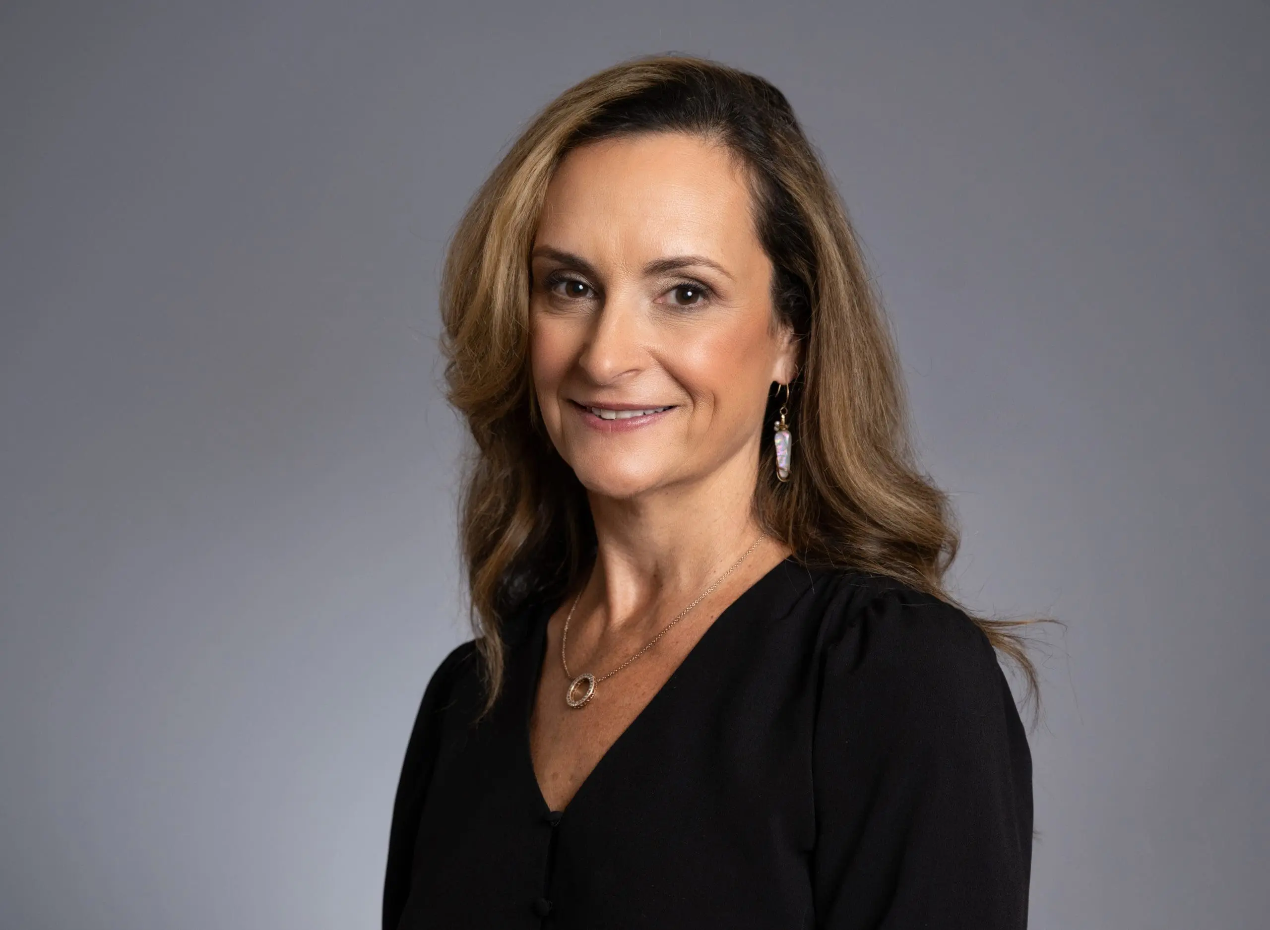 Lindsay Moran, a white woman with a black shirt, half-smiling and facing the camera.