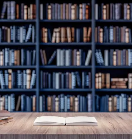 a shelf filled with books about severe mental illness, with an open book on a table in front of the bookshelf