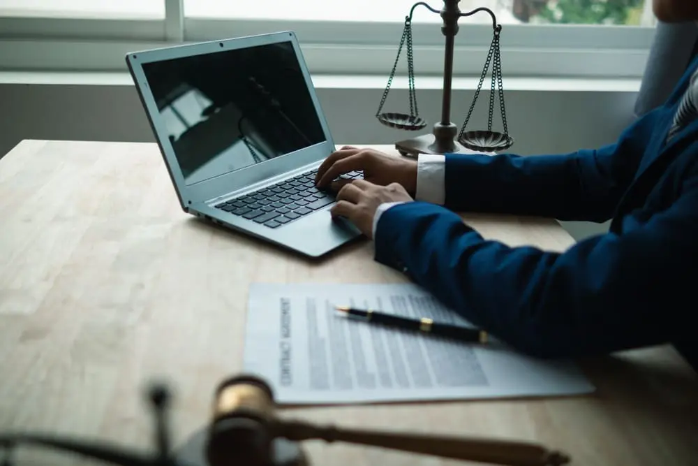 a desk with a laptop, gavel, and scales of justice, symbolizing legal resources for severe mental illness