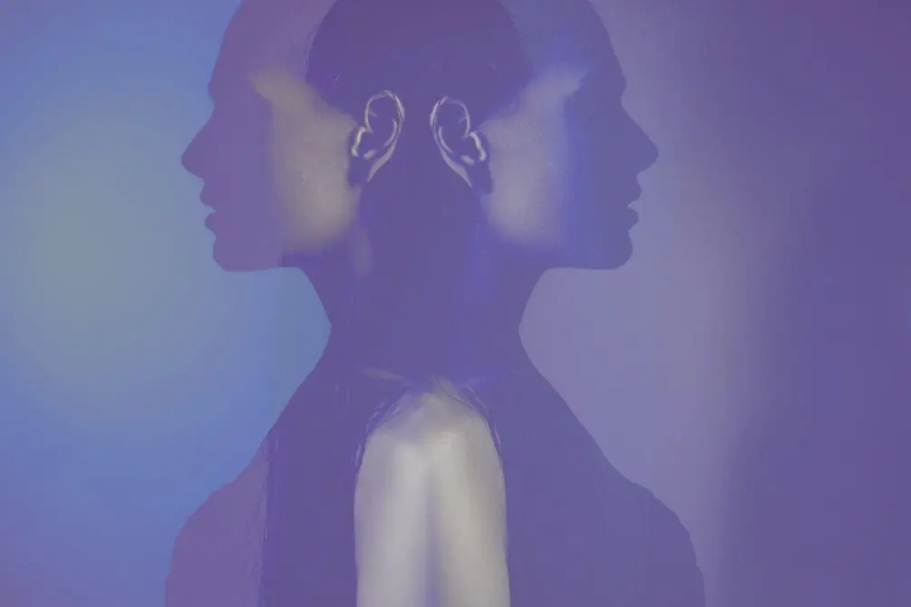A woman mirrored in shadows, symbolizing severe mental illness