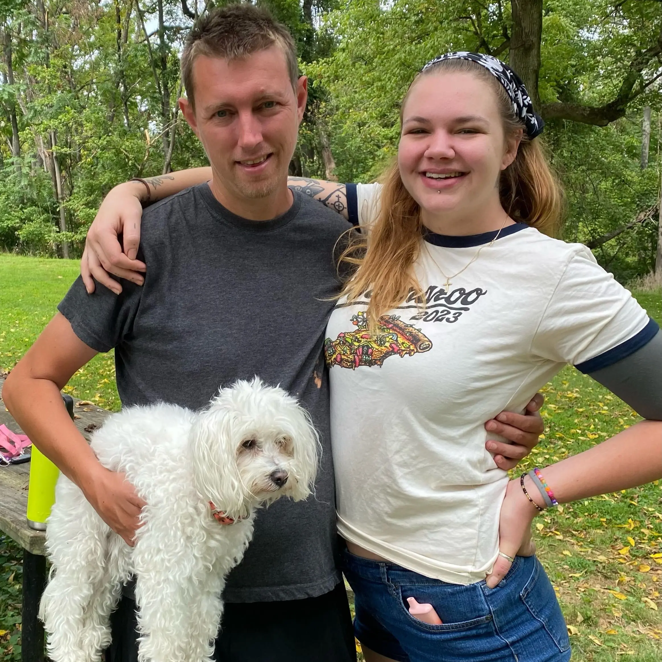 The author's daughter and son, with their arms around each other, with the son holding a small white dog.