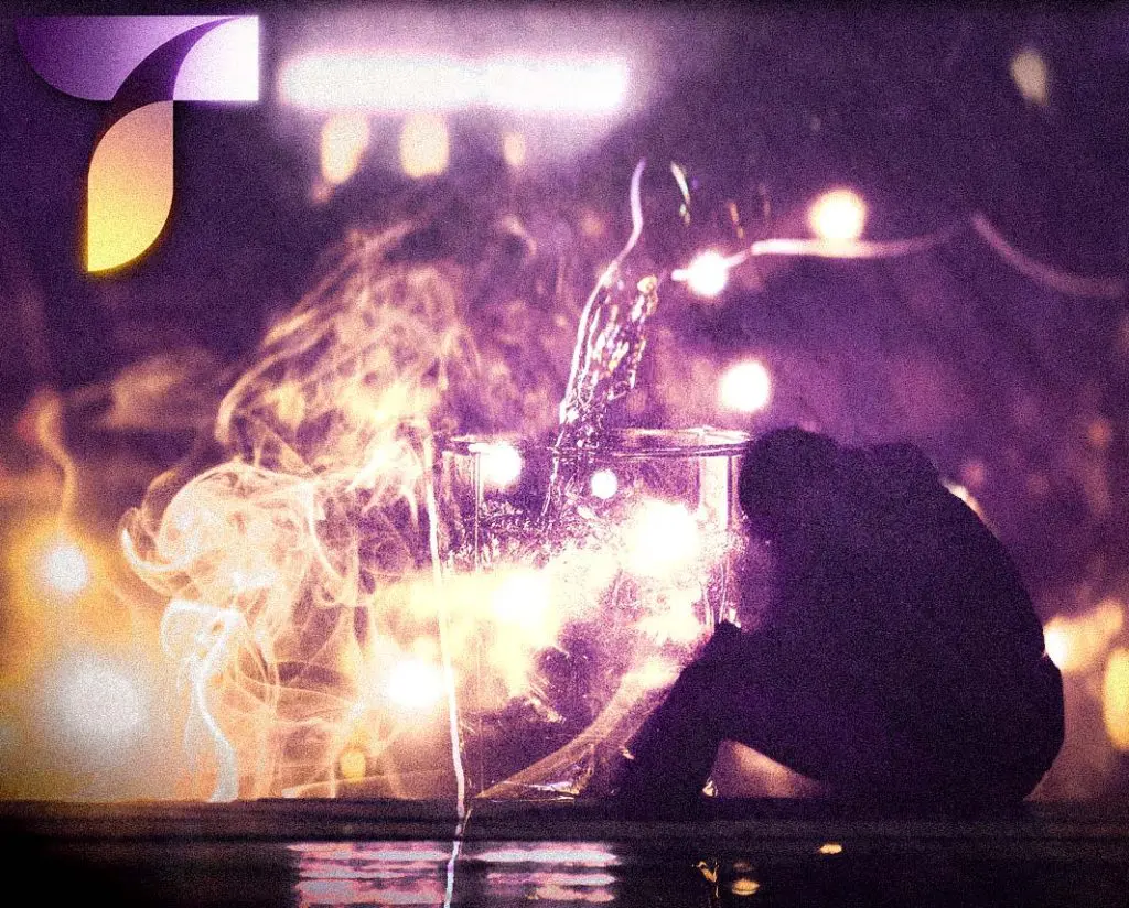A person sitting hunched in front of faint images of alcohol and smoke symbolizing substance use with schizophrenia